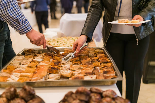 people serving themselves with food at restaurant event or conference.